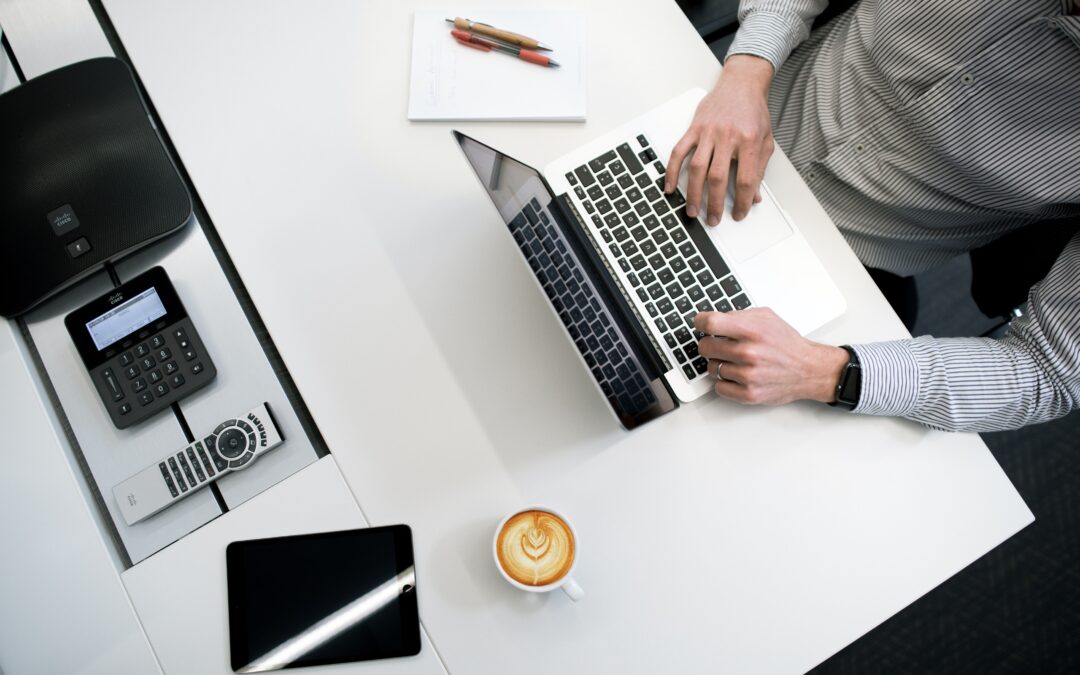 Top view of a desk with a professional working on his laptop write clear subject lines